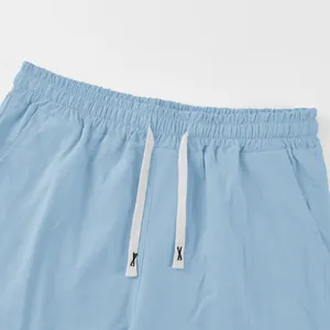Detailed view of light blue linen shorts waistband featuring white adjustable drawstrings