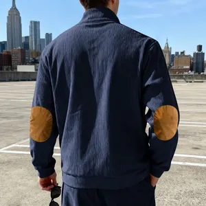 Navyblauwe corduroy sweater met bruine elleboogstukken, getoond vanaf de achterkant