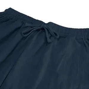 Close-up of drawstring elastic waistband on men's navy blue linen casual pants.