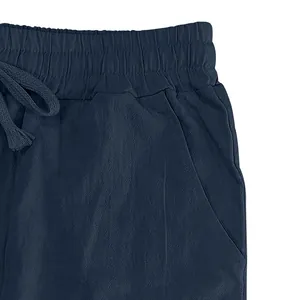 Detailed view of elastic waistband and drawstring on navy blue linen casual pants