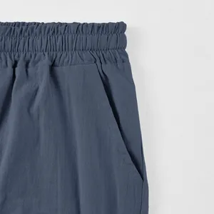 Detail of men's linen shorts showing elastic waistband and side pocket texture