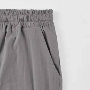 Close-up of men's linen shorts featuring elastic waistband and side pocket detail