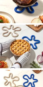 Detailed view of flower-shaped silicone heat mats being used with kitchen tools and food.