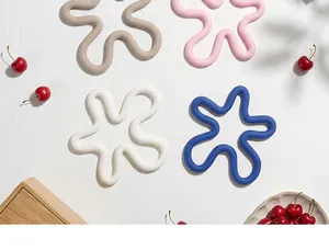 Set of colorful flower-shaped silicone heat-insulated coasters on a white surface