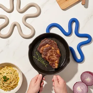 Flower-shaped silicone heat insulation pads shown on a marble table with kitchen props