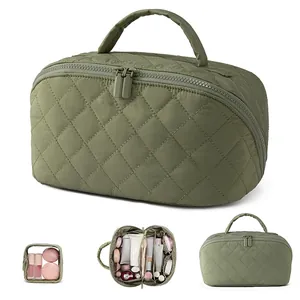 Quilted cosmetic bag with large capacity, portable handle and multiple inner storage compartments.