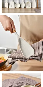 Close-up of cleaning a white silicone spatula featuring a natural acacia wood handle.