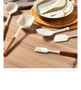 Detail of heat-resistant silicone kitchen utensil set with natural acacia wood handles.