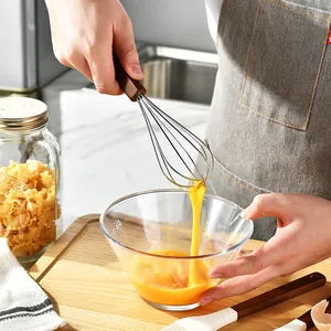 Manual stainless steel egg whisk with wooden handle used for professional home baking