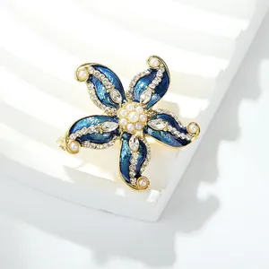 Close-up view of a luxury vintage starfish brooch with blue enamel, pearls, and rhinestones.