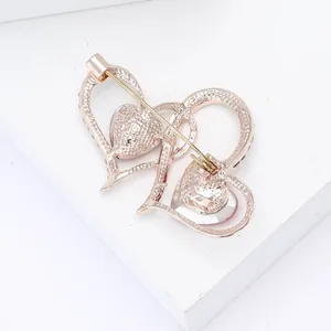 Vista detallada posterior de un broche de doble corazón en oro rosa con diamantes y pin