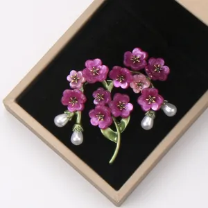 Macro shot of a vintage floral branch brooch featuring purple flowers and pearl drops