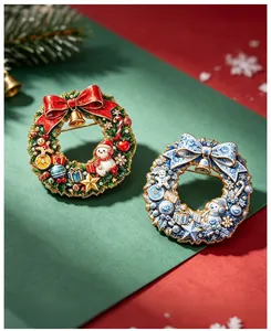 Macro view of festive Christmas wreath brooches featuring snowmen and bell designs.