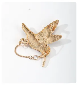 Gedetailleerd achteraanzicht van een gouden kolibriespeld met speld en ketting.