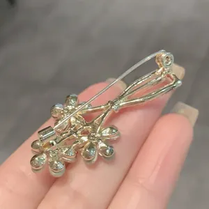 Detailed back view of creative golden flower vase brooch pin showing sturdy clasp
