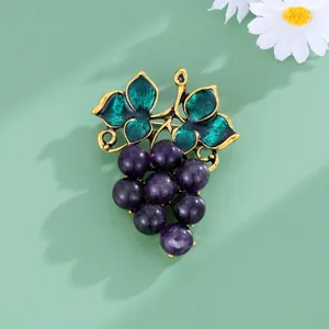 Vue détaillée d'une élégante broche de raisin violet avec feuilles en émail vert