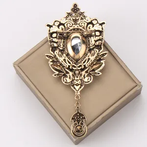 Back view of vintage gold hollow brooch with clear rhinestone and dangling tassel.