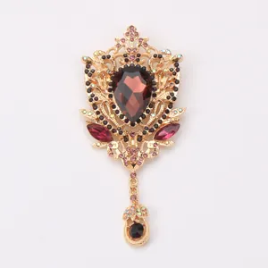 Detailed view of vintage court brooch with wine red crystal and gold hollow-out metalwork