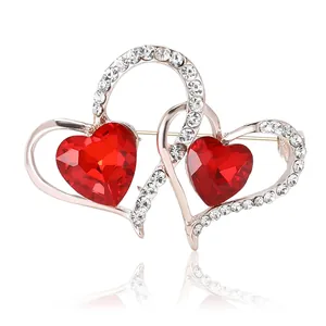 Elegante broche de doble corazón en oro rosa con cristales rojos facetados y brillantes