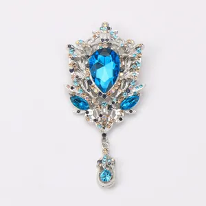 Detailed macro shot of a vintage palace style brooch with blue crystal and rhinestones.