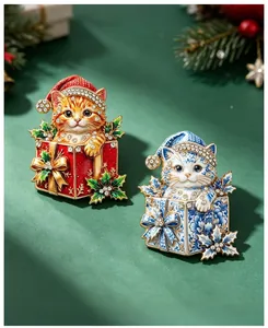 Dettaglio di spille natalizie a forma di gatto con strass brillanti e smalto colorato.