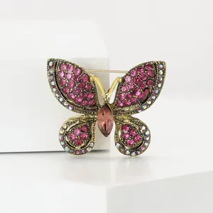 Vue détaillée d'une broche papillon en or vintage avec des strass roses scintillants