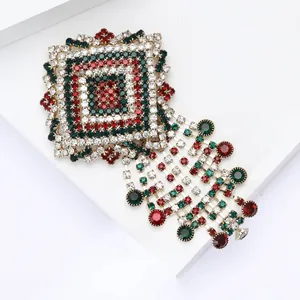 Detailed view of luxury alloy brooch with red and green rhinestones and tassel chains