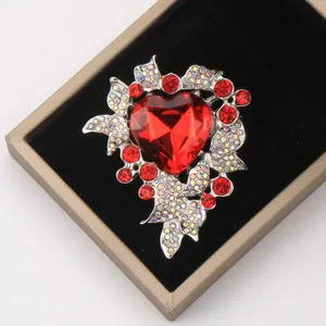Close-up of luxury heart-shaped brooch with red gems in a black velvet jewelry box