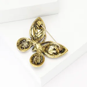 Vue arrière détaillée d'une broche papillon en alliage d'or antique avec fermoir