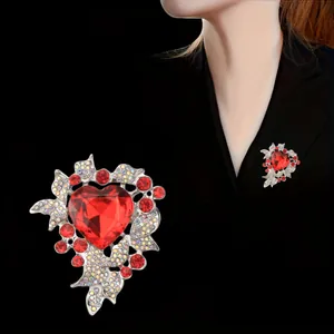 Elegant luxury heart-shaped brooch featuring a large red crystal and sparkling rhinestones