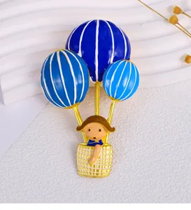Adorable enamel hot air balloon girl brooch crafted in golden alloy and blue resin