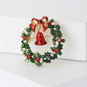 Gedetailleerde weergave van een emaille kerstkrans broche met een rode bel en strik