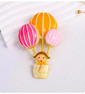 Close-up of a cute cartoon hot air balloon girl brooch with colorful enamel finish