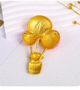 Detailed back view of golden cartoon hot air balloon girl brooch with safety pin
