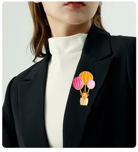 Detail shot of a cute hot air balloon brooch with a girl figure on a blazer lapel.
