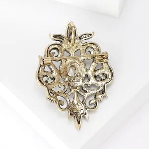Detailed back view of vintage Baroque hollow alloy brooch with a secure gold pin clasp