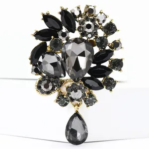 Detaillierte Nahaufnahme einer grauen Strass-Blumenbrosche mit Tropfenanhänger im Vintage-Stil