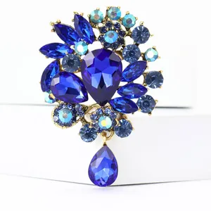 Detailansicht einer Brosche im Vintage-Stil mit blauen Strasssteinen und Tropfenkristall.