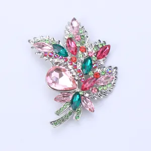 Detail of elegant alloy bouquet brooch featuring pink and green crystals for suits.