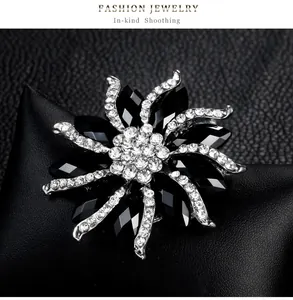 Elegant black crystal starburst brooch with clear rhinestone accents in silver finish