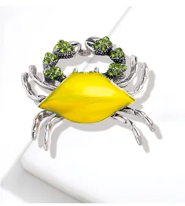 Elegant silver alloy crab brooch featuring vibrant yellow enamel and green rhinestones