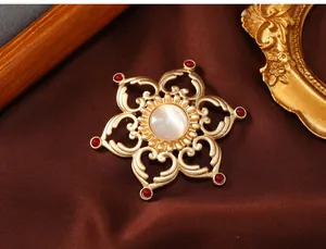 Detailed shot of a vintage gold-toned hollow lotus brooch with a center opal stone.