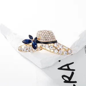 Macro detail of elegant gold hat brooch with blue crystals and sparkling rhinestones