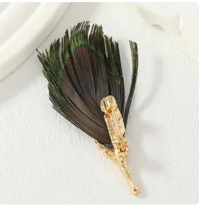 Detailed back view of luxury peacock feather brooch with gold-colored metal clasp