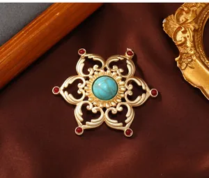 Detail view of vintage gold-plated lotus brooch with central turquoise-like stone