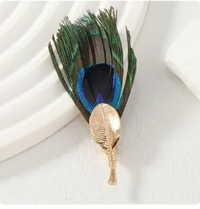 Luxury handmade peacock feather brooch with golden leaf-shaped metallic pin detail