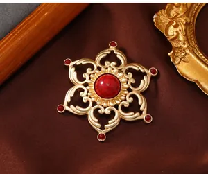 Macro detail of a vintage gold hollow lotus brooch with an elegant red stone inlay