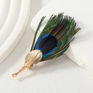 Elegant handmade natural peacock feather brooch with gold leaf base for suits and coats