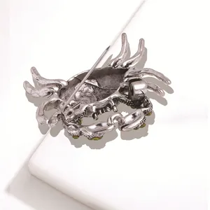 Antique silver crab brooch back view showing pin mechanism with green rhinestones