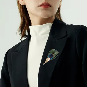 Elegant handmade peacock feather brooch on a professional black blazer suit jacket